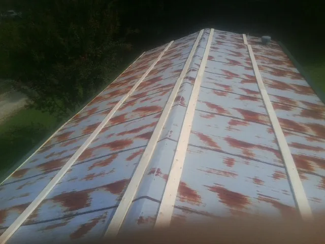 Rusted metal roof panels with new wood purlins before replacement — Storm Damage Roof Repair in Kaleva by Roofing Brothers