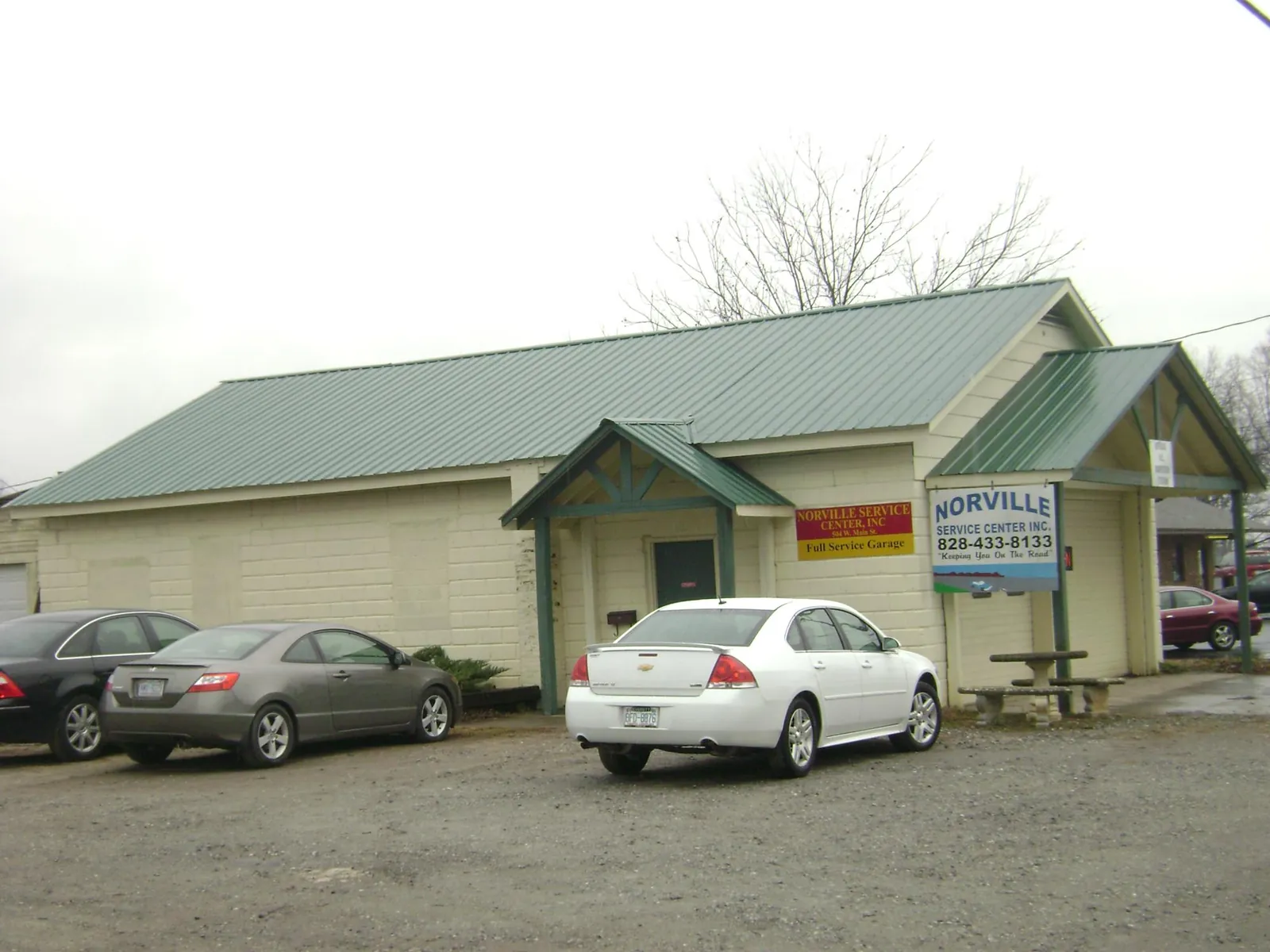 Green metal roof on a service garage with a covered entry in Kaleva