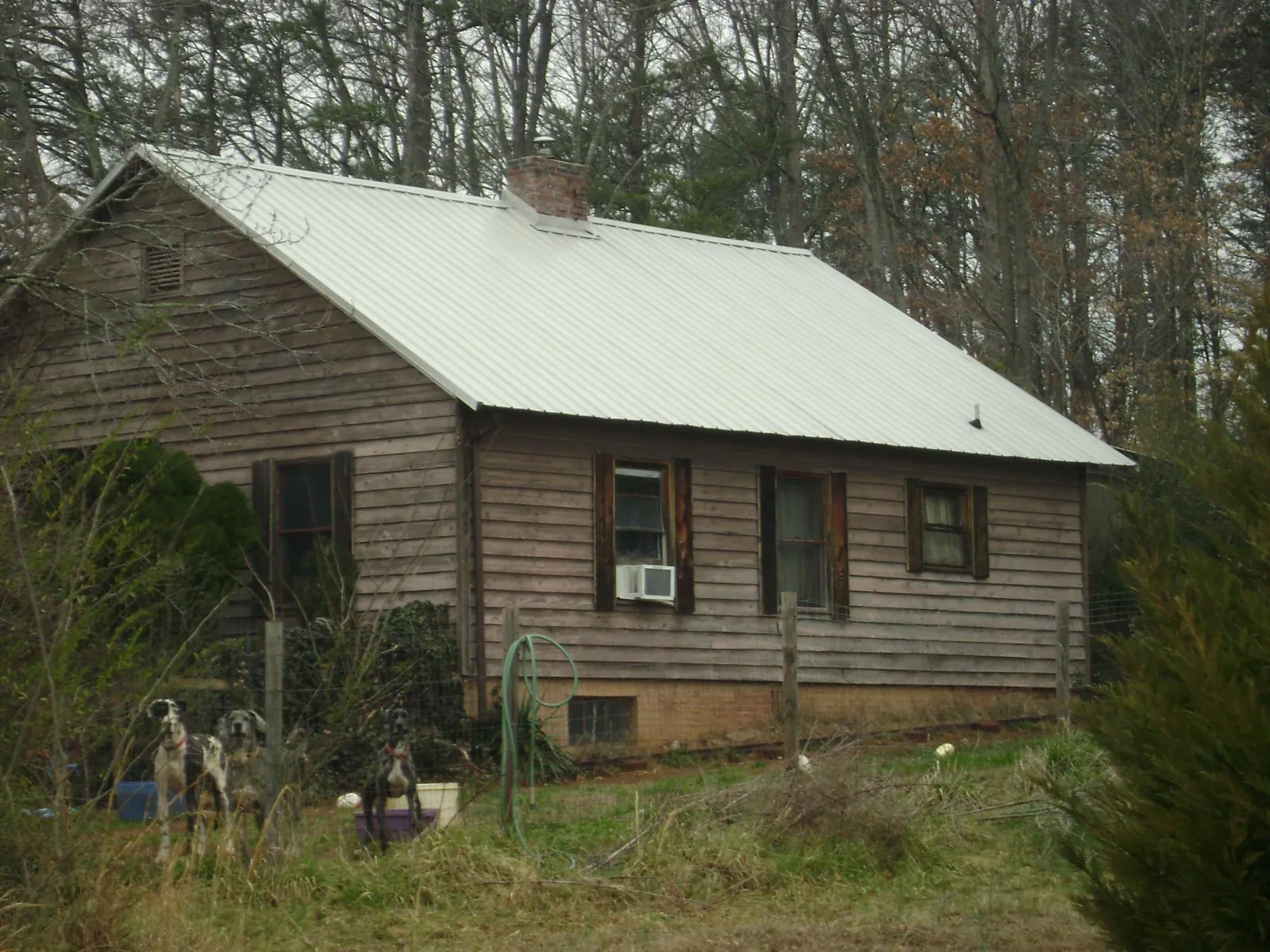 White metal roof on an old wood sided farmhouse, from a Metal Roof Installation job in Kaleva